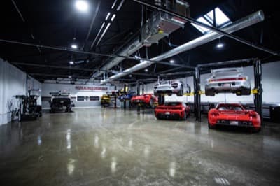 Wide shop floor with red and silver Carrera GTs on lifts at Repasi Motorwerks