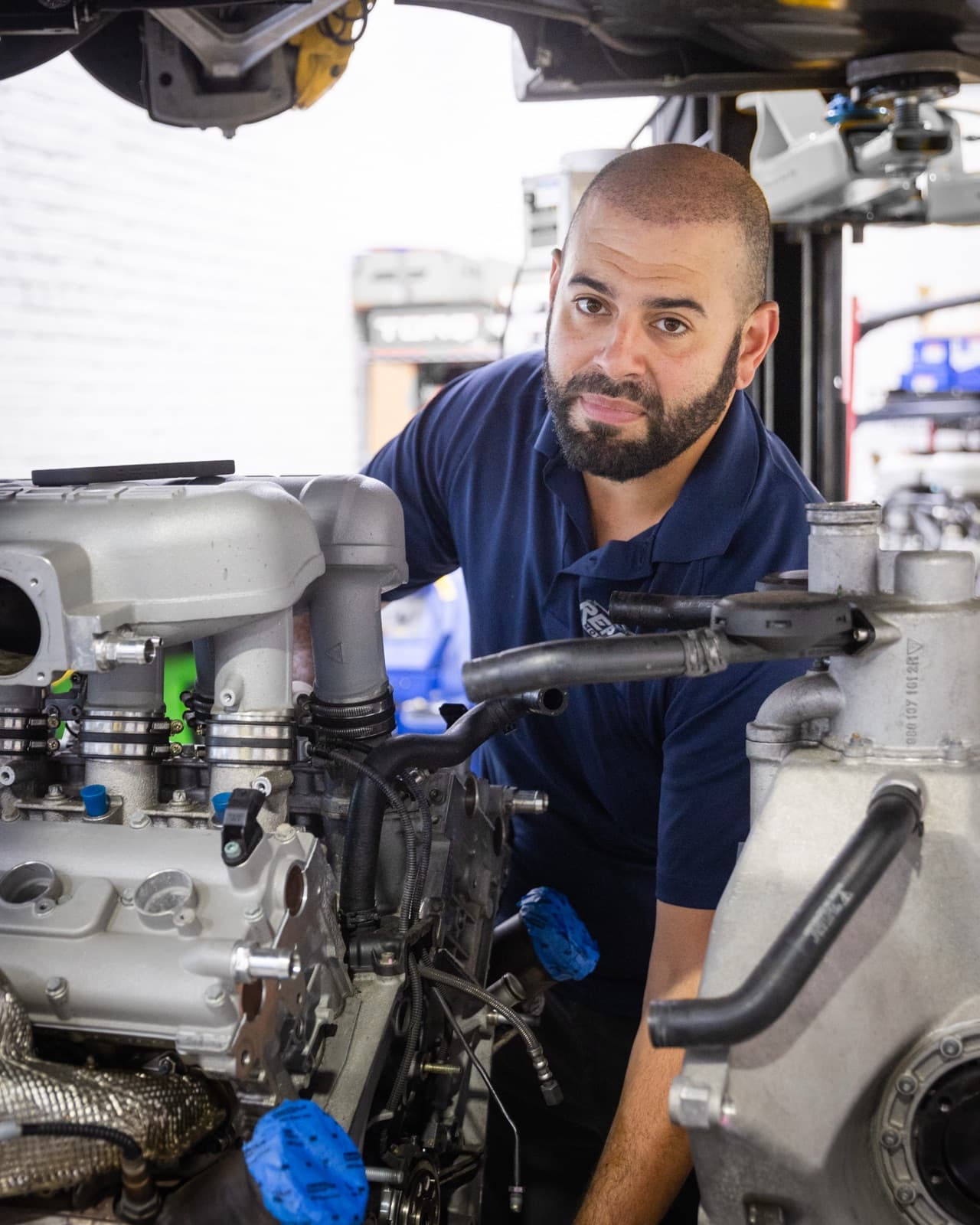 Technician performing detailed engine inspection during PPI