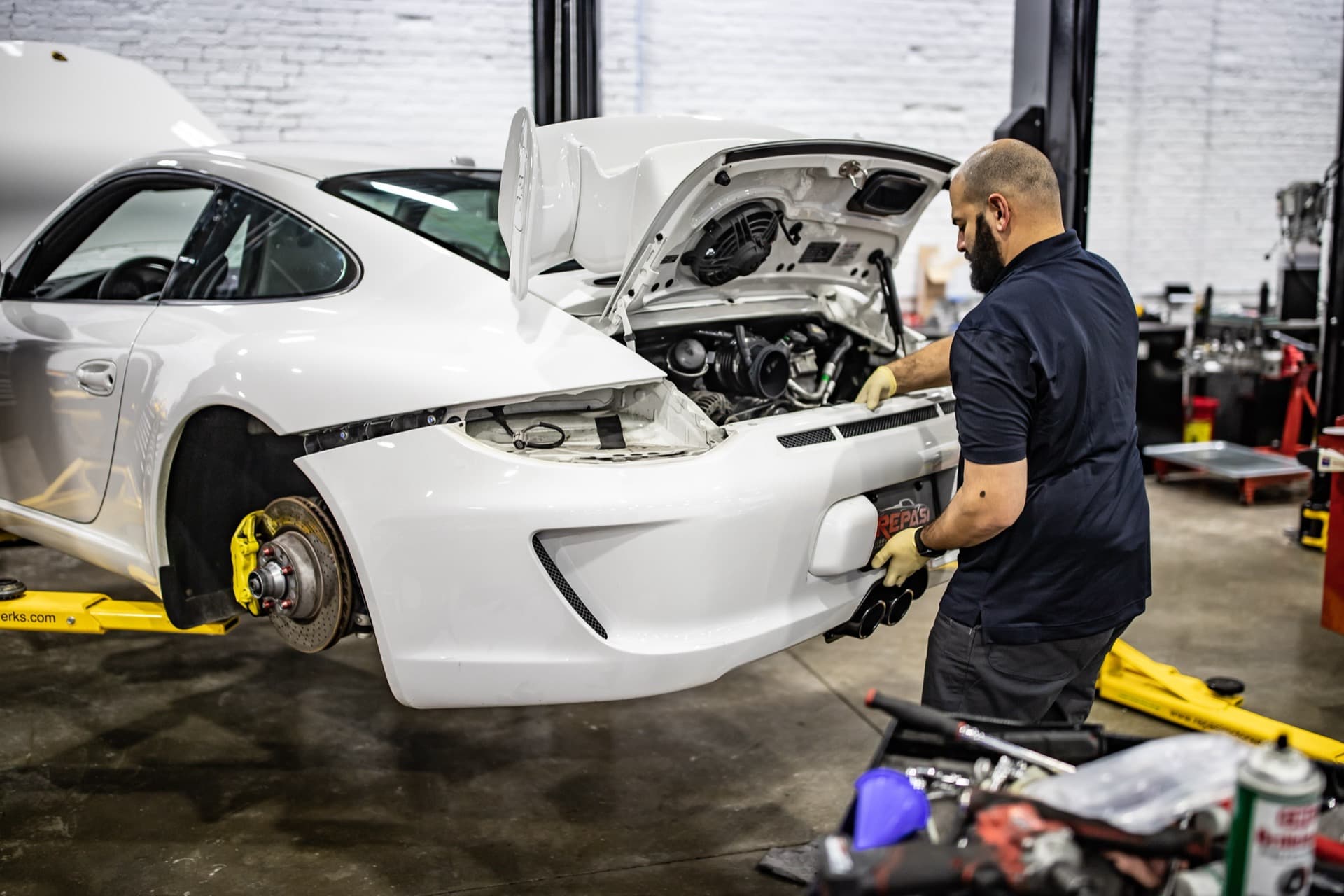 White Porsche 991 GT3 with rear bumper removed for factory-interval maintenance at Repasi Motorwerks in Stratford, CT